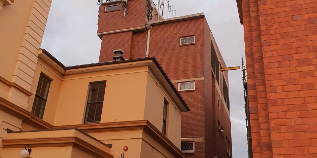 A tool brick building behind the Goulburn Post office, antennas can be seen on the roof that resemble those of cellular/moible networks.