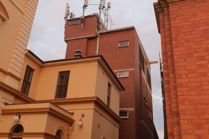 A tool brick building behind the Goulburn Post office, antennas can be seen on the roof that resemble those of cellular/moible networks.