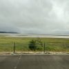 Picture shows grey sky and Lake George full of water from the roadside.